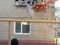 Пострадавший, во время обстрела, жилой многоэтажный дом в Горловке зашили временно древесными плитами (фото)