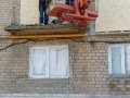 Пострадавший, во время обстрела, жилой многоэтажный дом в Горловке зашили временно древесными плитами (фото)
